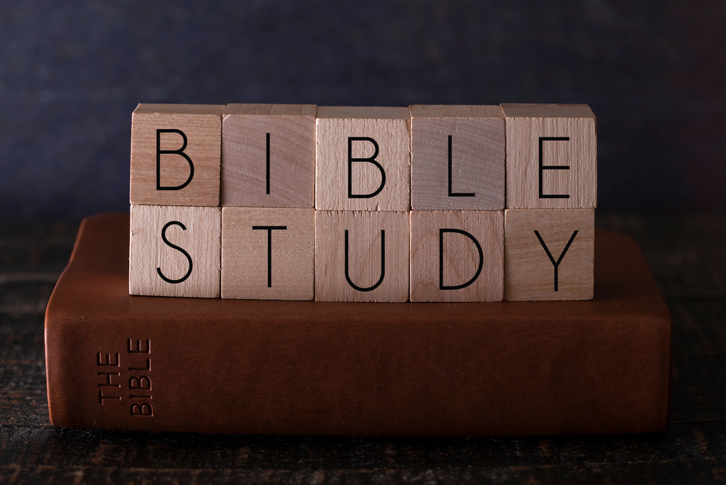 Bible Study Spelled in Block Letters on a Wooden Table with a Bible